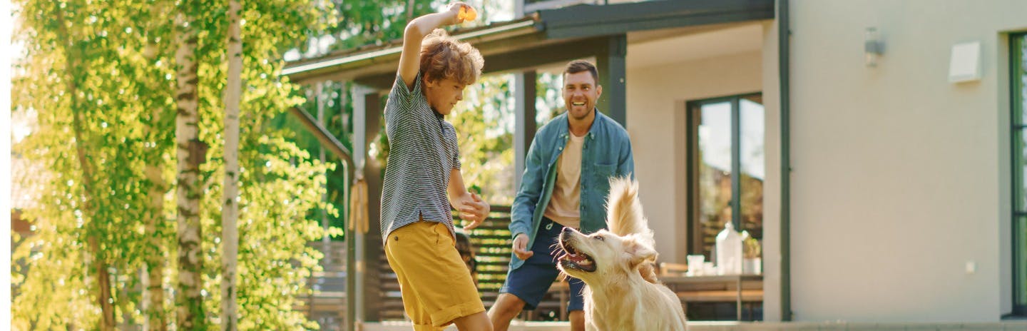 Father and son playing with dog
